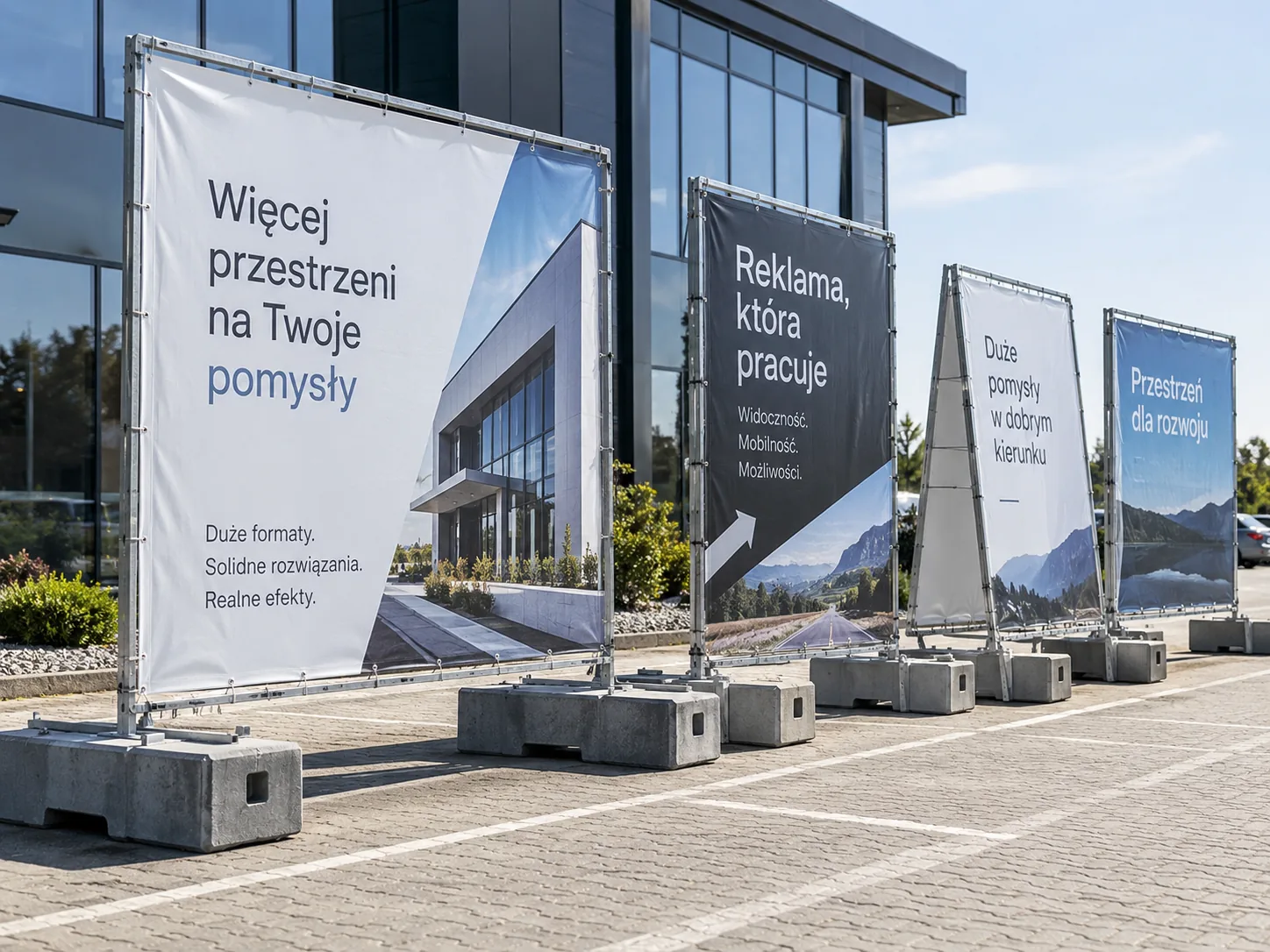Tablice obciążone: ramy z banerami ustawione na betonowych blokach przed budynkiem firmy